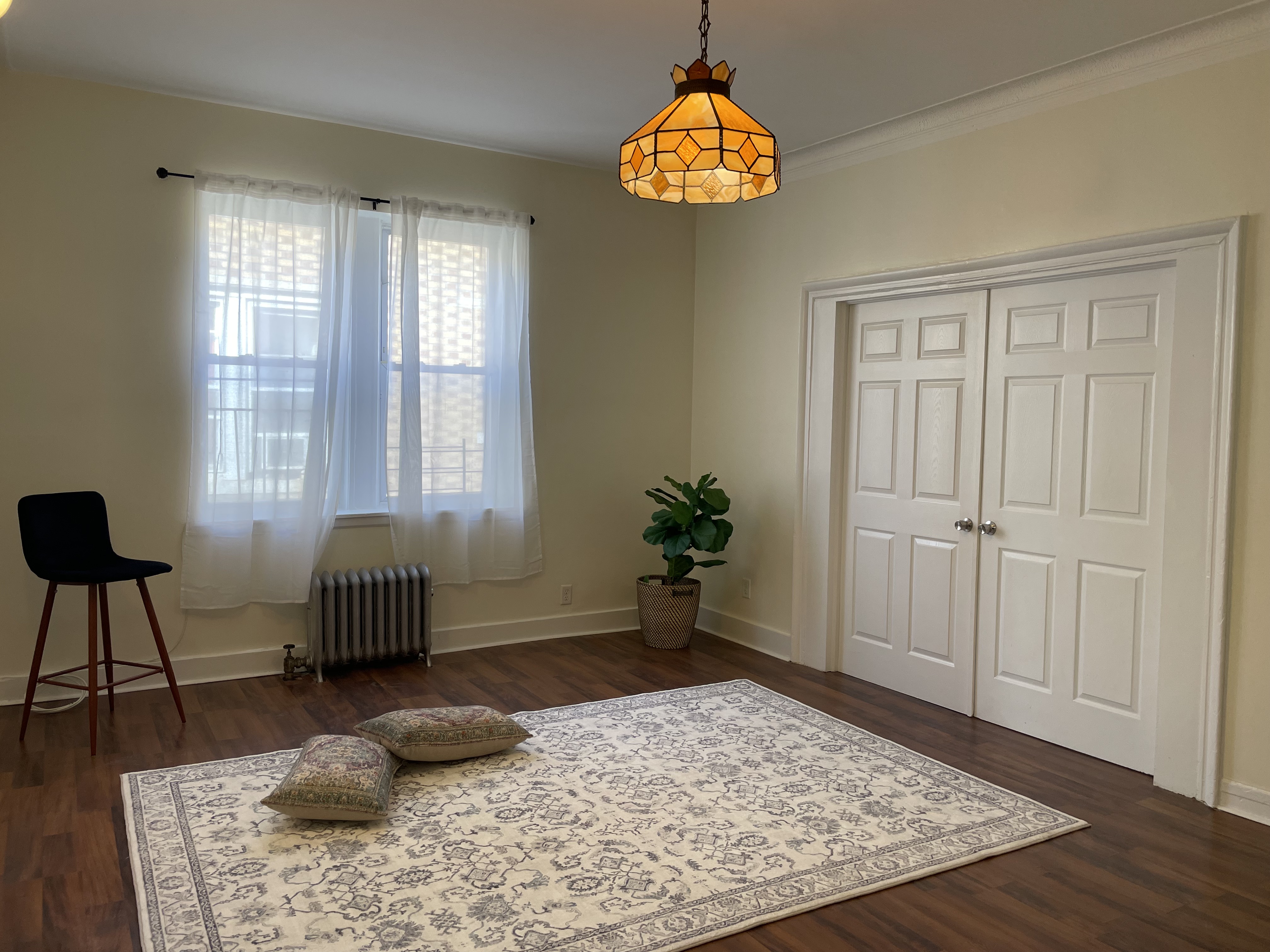 2446 Bedford Avenue, Unit 1 Brooklyn, NY 11226 - Photo 3 of 15 a bedroom with a bed and a chandelier