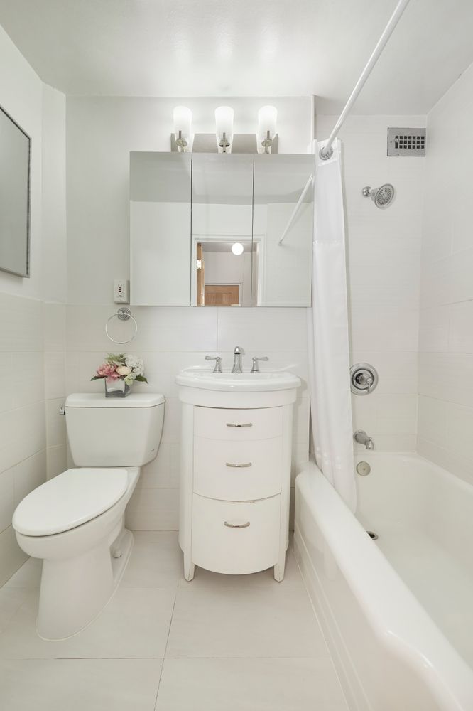 225 East 46th Street, Unit 4K Manhattan, NY 10017 - Photo 8 of 14 a bathroom with a sink mirror vanity and toilet