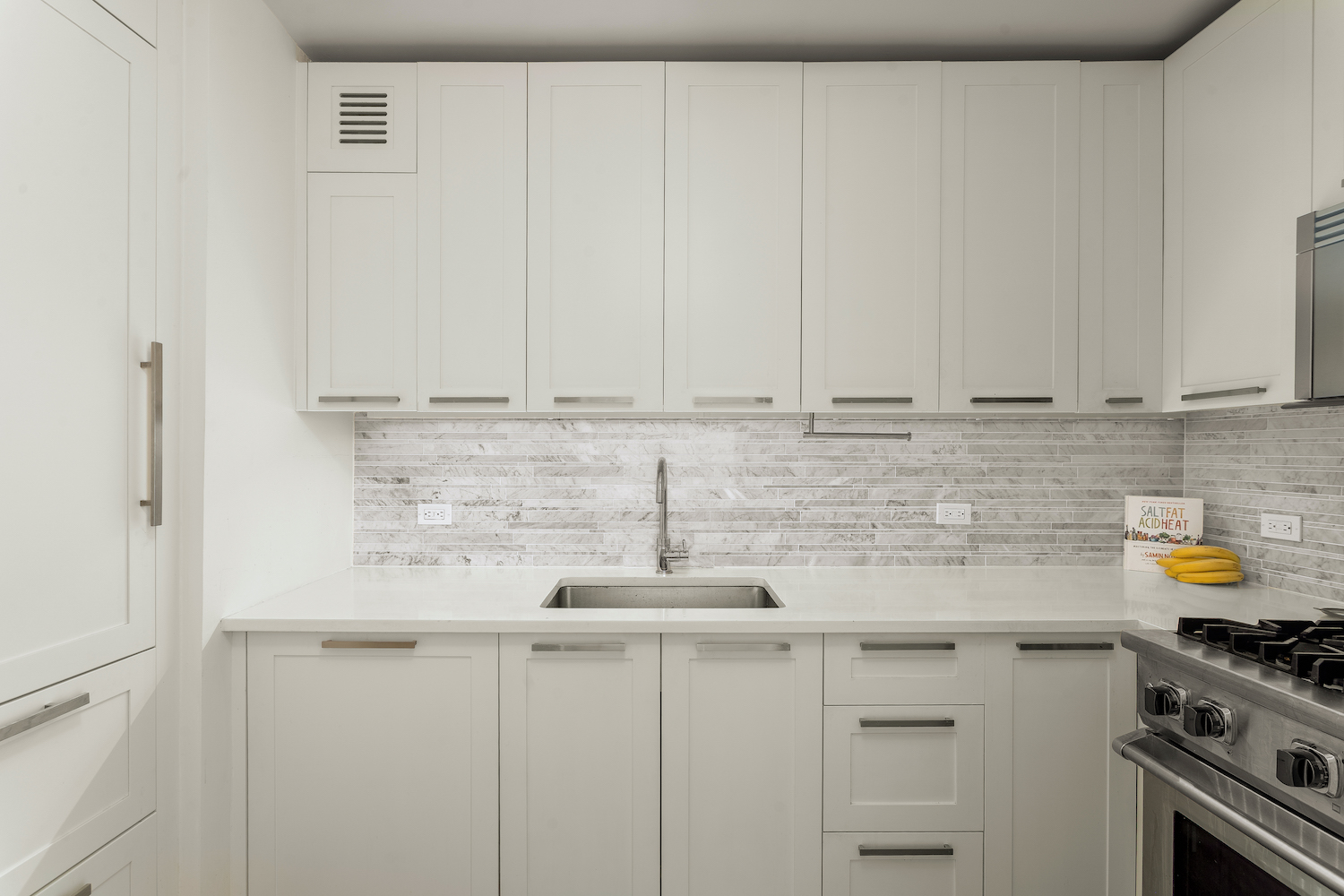 200 East 94th Street, Unit 2015 Manhattan, NY 10128 - Photo 5 of 16 a kitchen with stainless steel appliances white cabinets and a stove