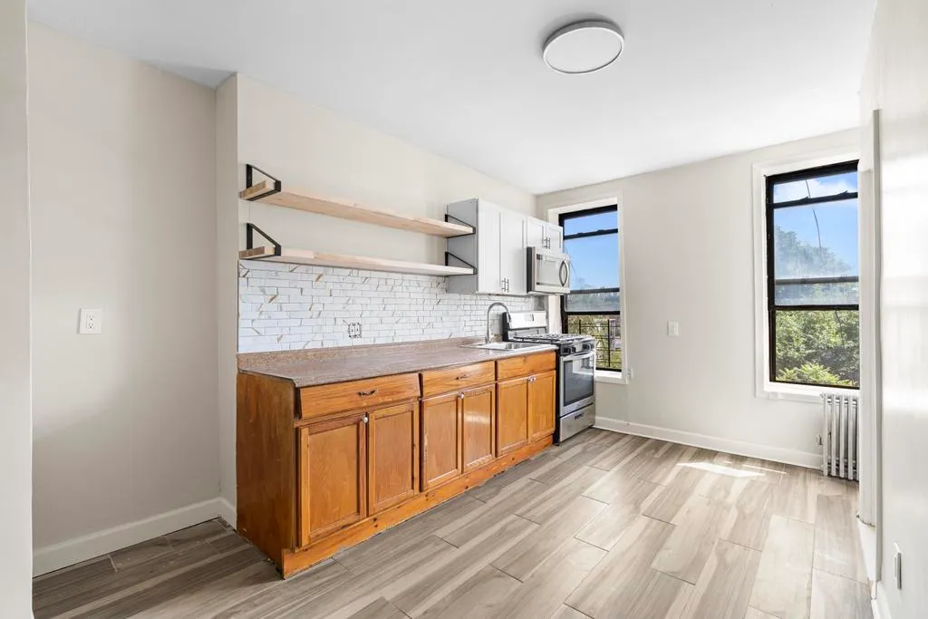 a kitchen with granite countertop a stove a sink and a refrigerator