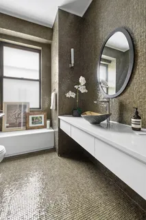 a bathroom with a tub sink and mirror
