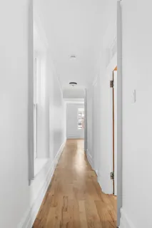 a view of a hallway with wooden floor