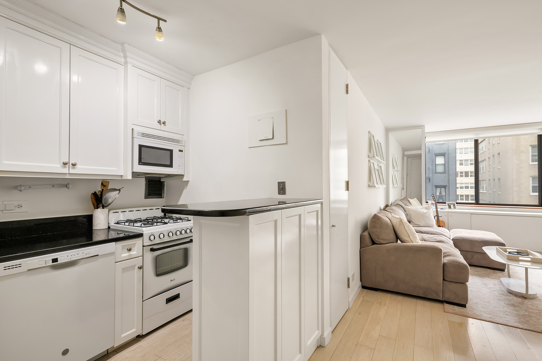 330 East 75th Street, Unit 3L Manhattan, NY 10021 - Photo 4 of 14 a living room with stainless steel appliances white cabinets and a couch