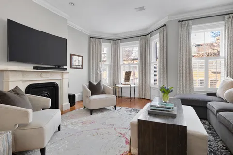 a living room with furniture a flat screen tv and a fireplace