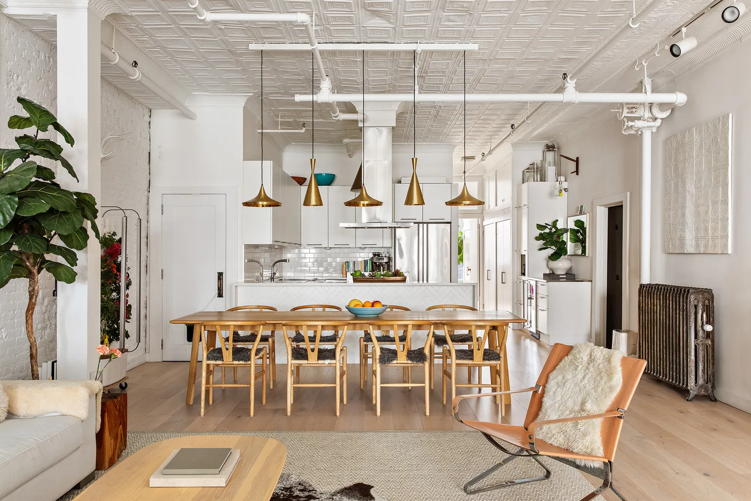 a dining room with furniture a kitchen and chandelier