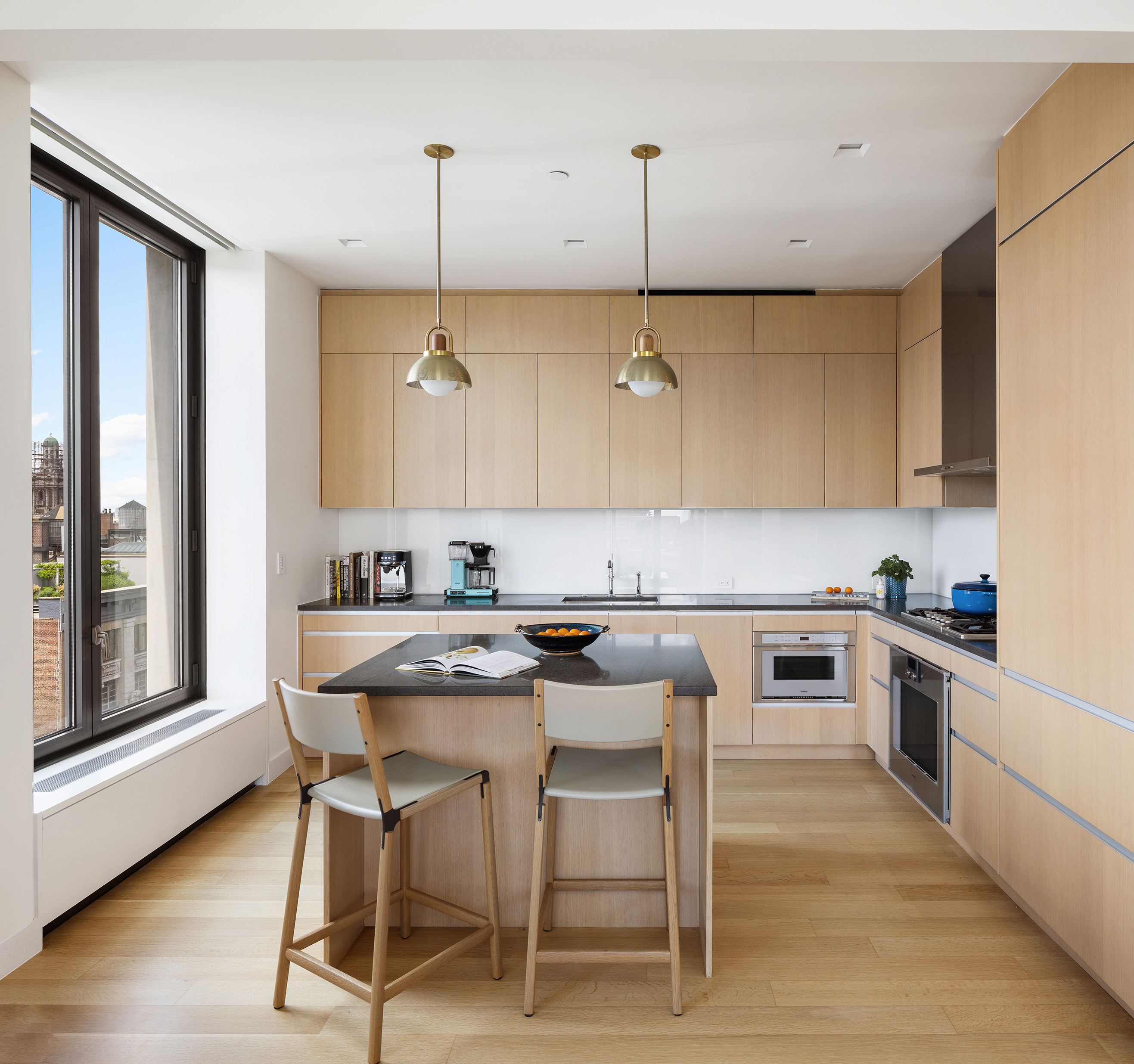 21 East 12th Street, Unit 17B Manhattan, NY 10003 - Photo 4 of 13 a kitchen with a table chairs stove and microwave