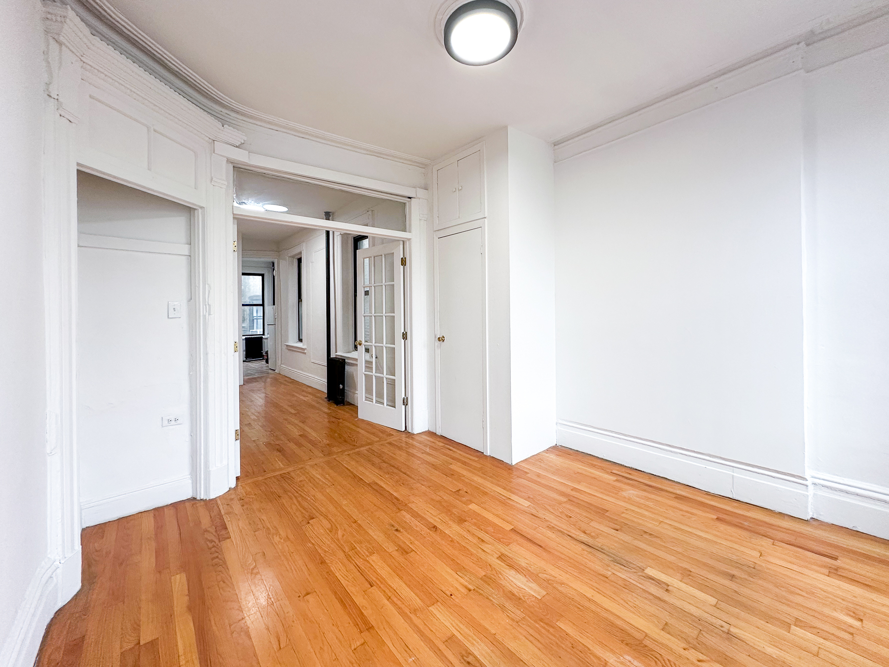 338 East 5th Street, Unit 17 Manhattan, NY 10003 - Photo 2 of 14 a bedroom with a bed and a chandelier fan