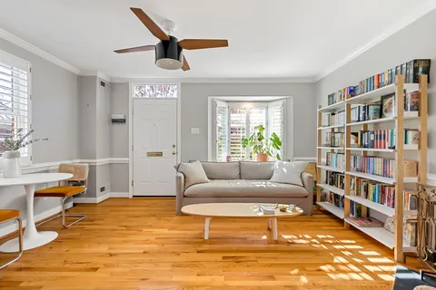 a living room with furniture and a book shelf