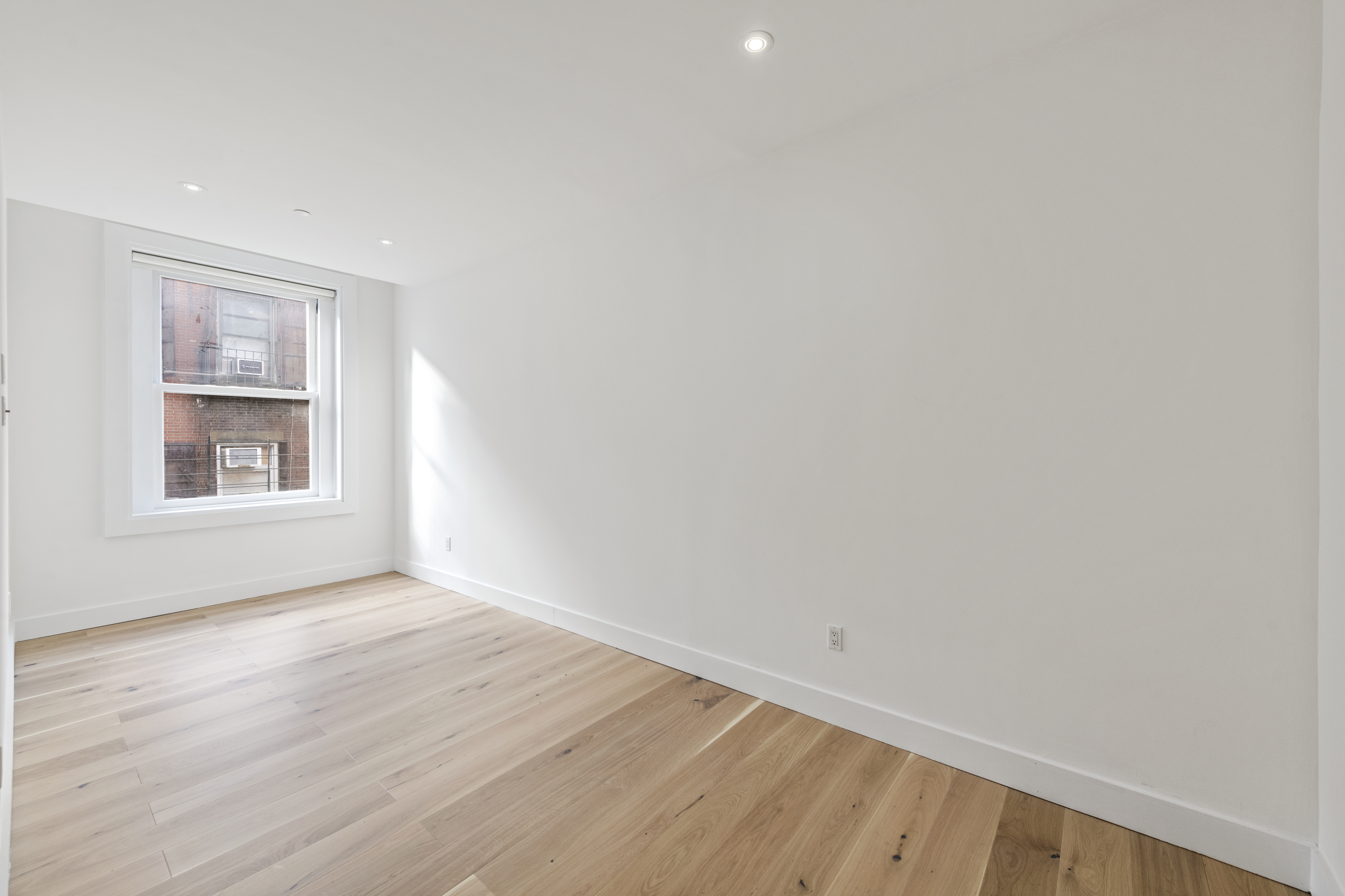 49 Walker Street, Unit PH Manhattan, NY 10013 - Photo 10 of 14 a view of an empty room with wooden floor and a window