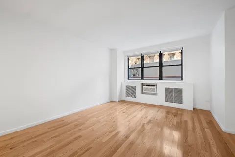 a view of a room with wooden floor and window