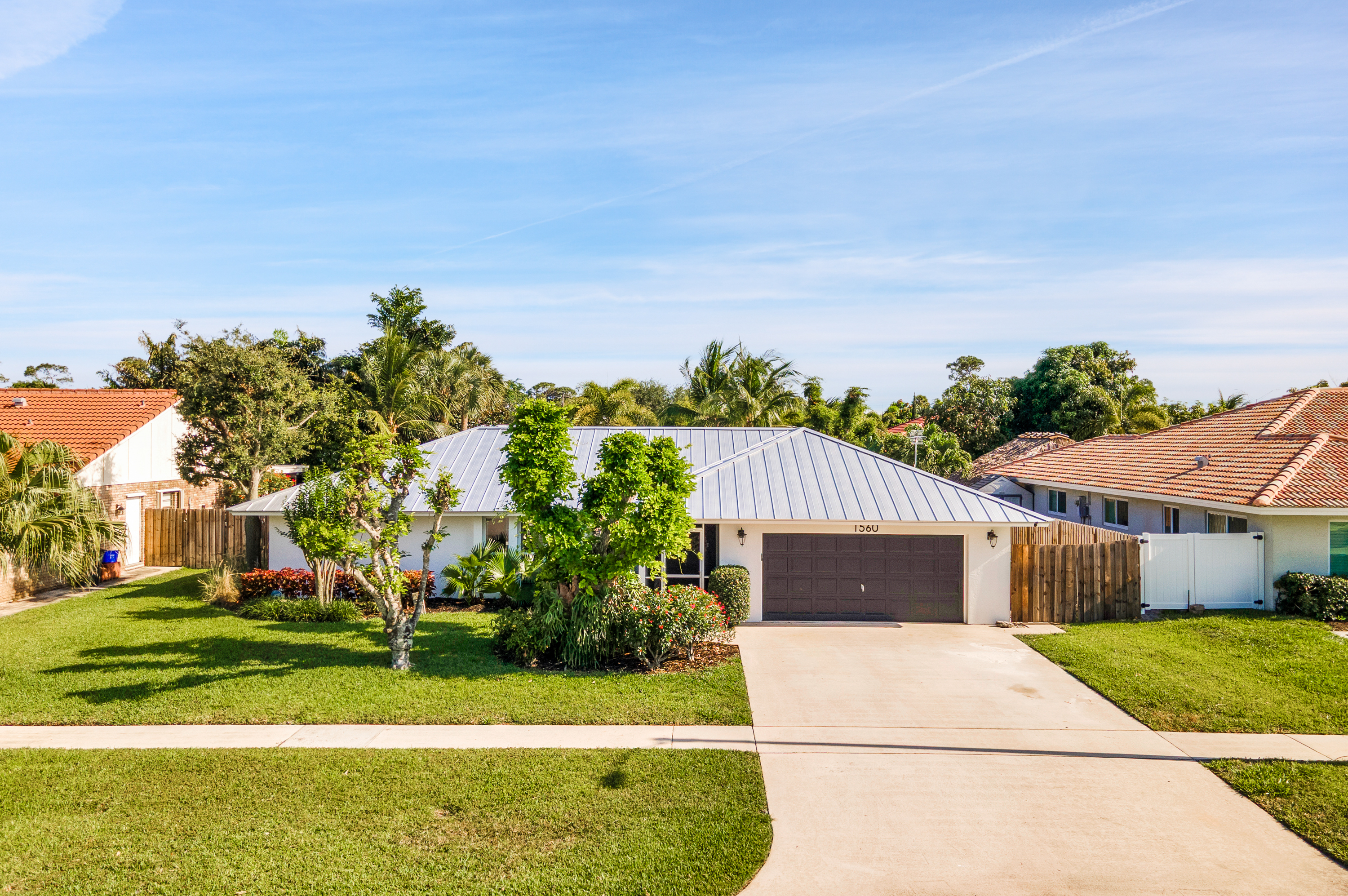 1560 Southwest 16th Street Boca Raton, FL 33486 - Photo 68 of 72 a front view of a house with a yard and garage