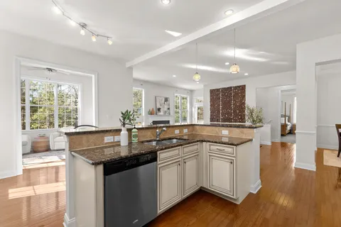 a kitchen with sink stove and wooden floor