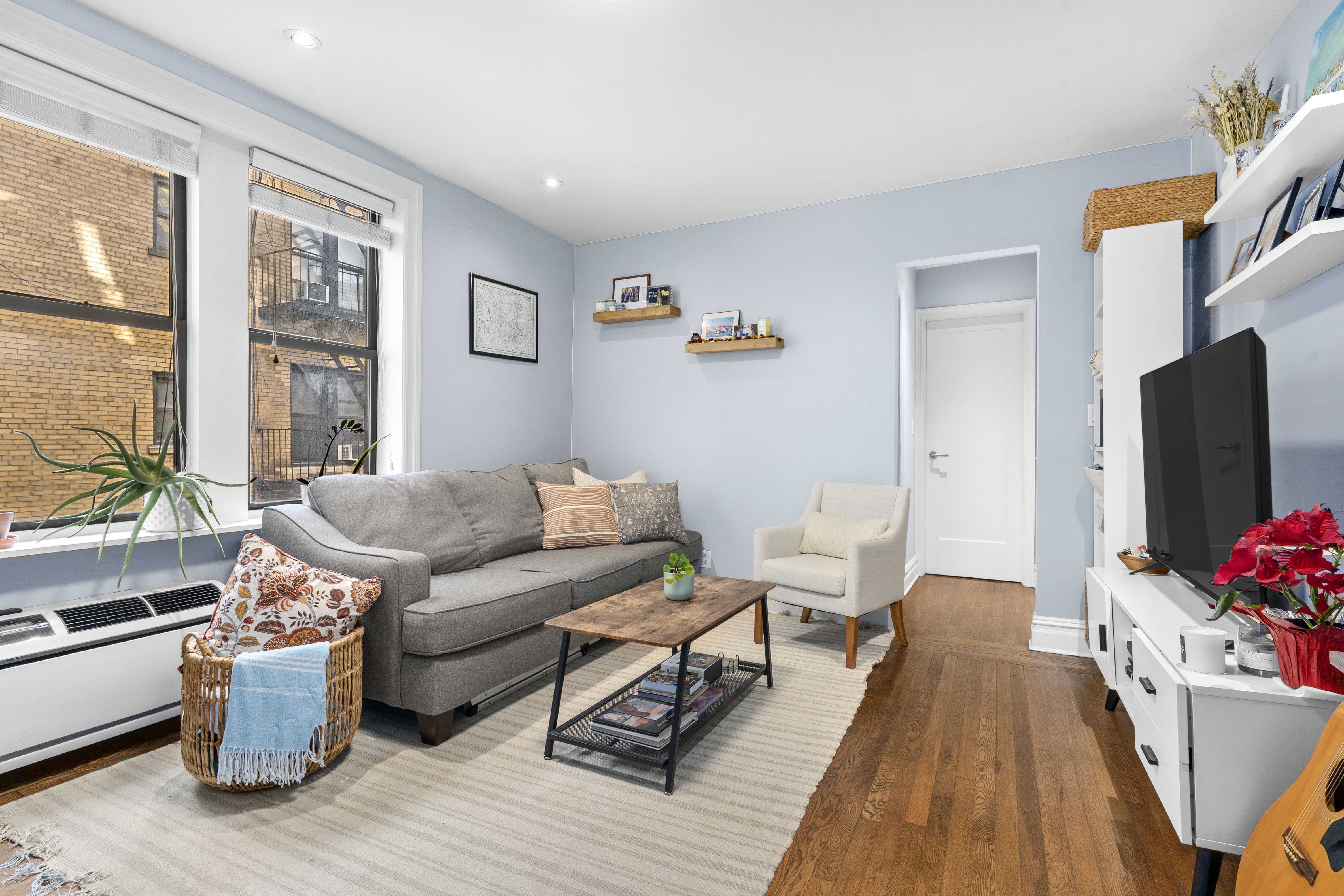 319 West 18th Street, Unit 4H Manhattan, NY 10011 - Photo 2 of 6 a living room with furniture and a flat screen tv