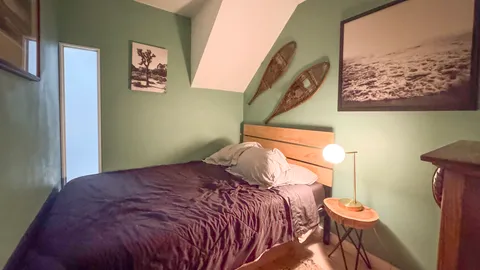 a bedroom with a bed and a painting on the wall