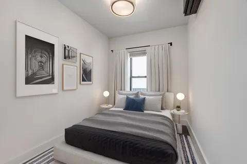 a bedroom with a bed and painting on the wall