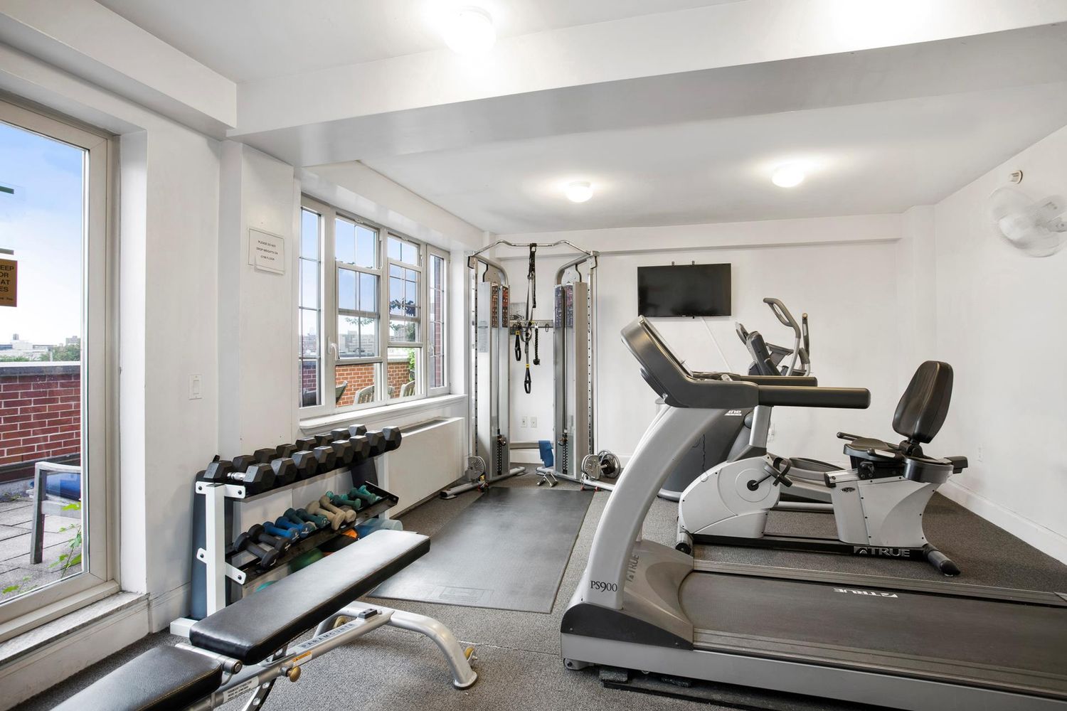 163 St Nicholas Avenue, Unit 2J Manhattan, NY 10026 - Photo 9 of 13 a room with gym equipment and a large window