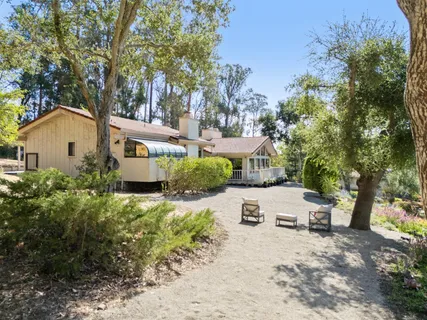 a view of a house with a yard and sitting area