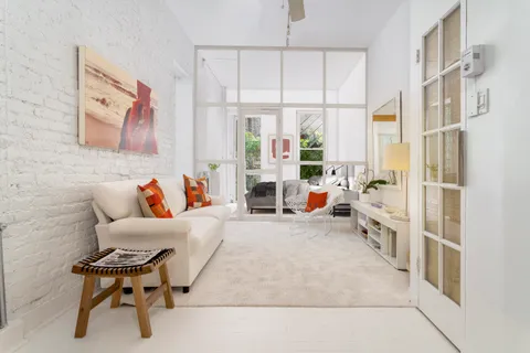 a living room with furniture large window and table