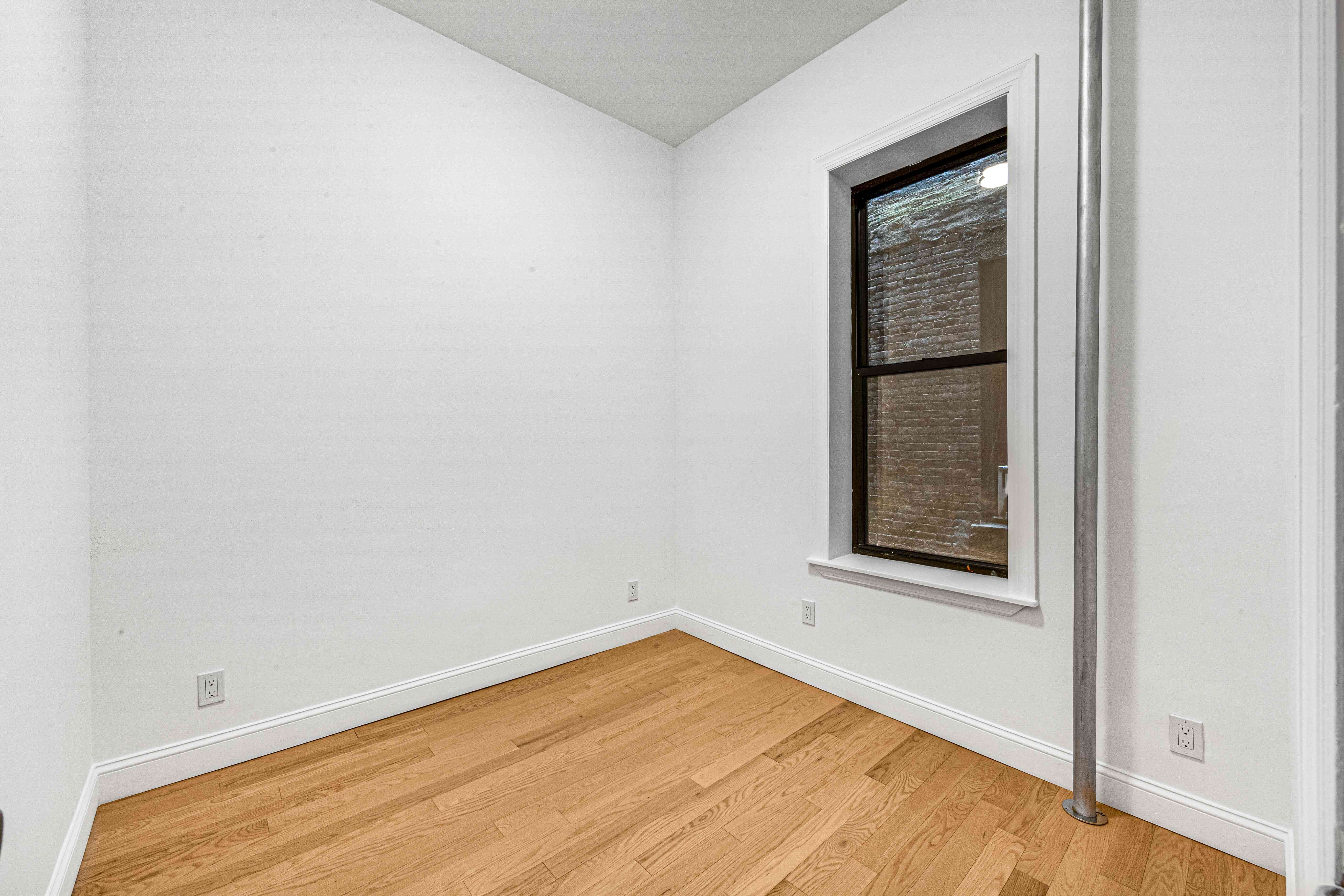 304 East 11th Street, Unit 1C Manhattan, NY 10003 - Photo 14 of 16 a view of empty room with wooden floor and fan