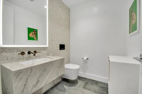 a bathroom with a sink mirror and toilet