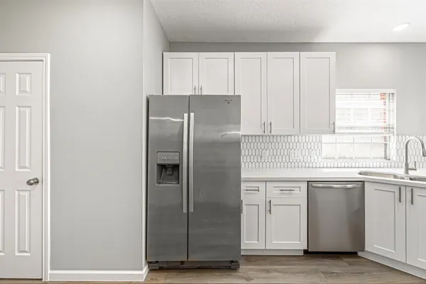 a kitchen with a refrigerator sink and cabinets