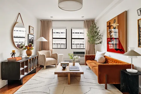 a living room with furniture a rug and a window