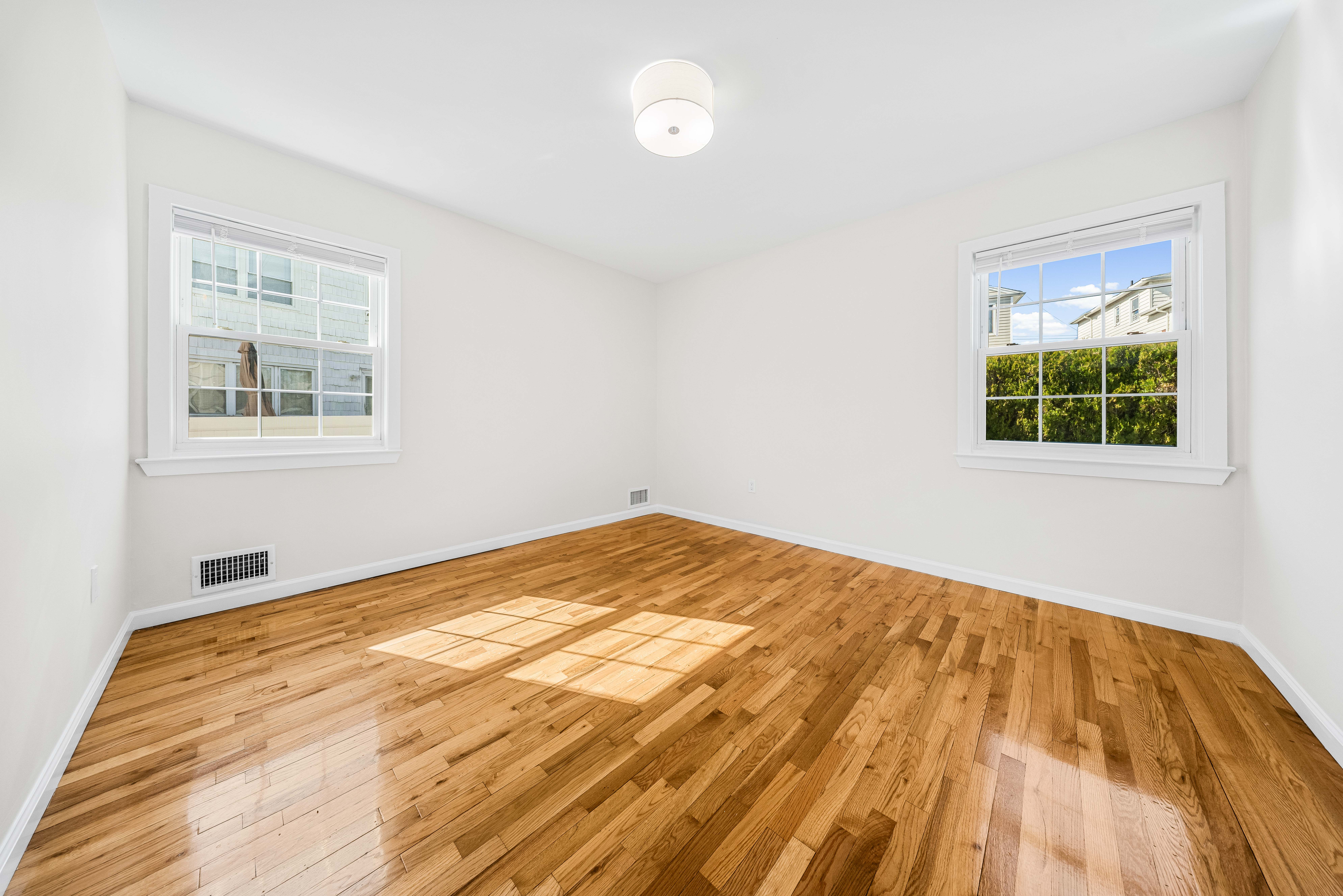 15-80 209th Street, Unit 2 Queens, NY 11360 - Photo 15 of 21 a bedroom with a bed and a window