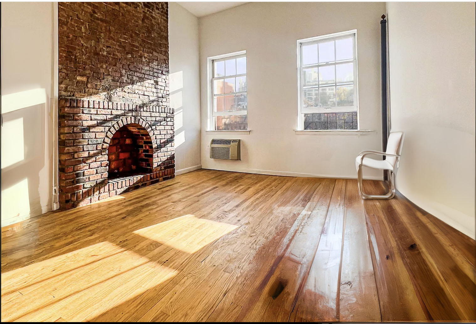 335 West 21st Street, Unit 4FE Manhattan, NY 10011 - Photo 3 of 11 an empty room with wooden floor a fireplace and windows