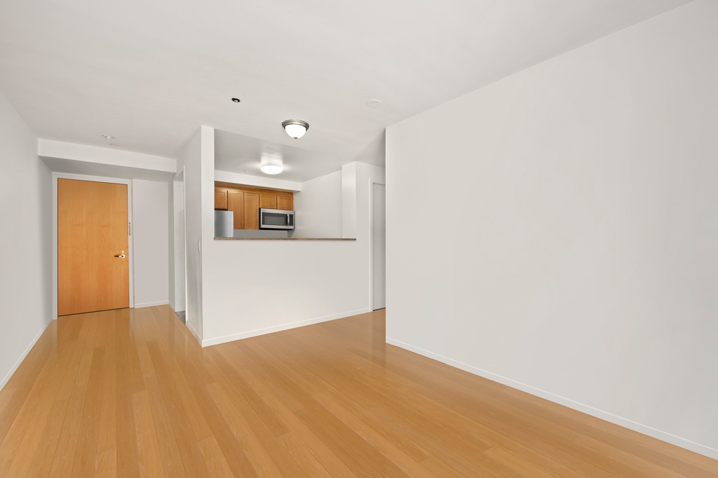 2132 2nd Avenue, Unit 2D Manhattan, NY 10029 - Photo 6 of 6 a view of a big room with wooden floor and windows