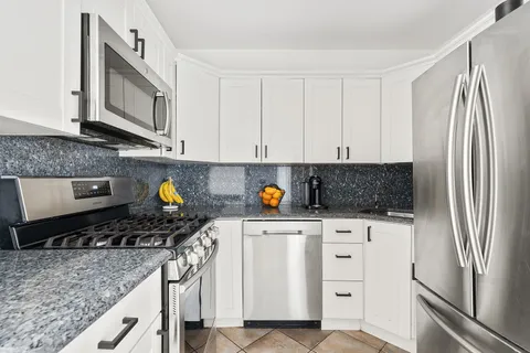 a kitchen with stainless steel appliances granite countertop a refrigerator stove and microwave