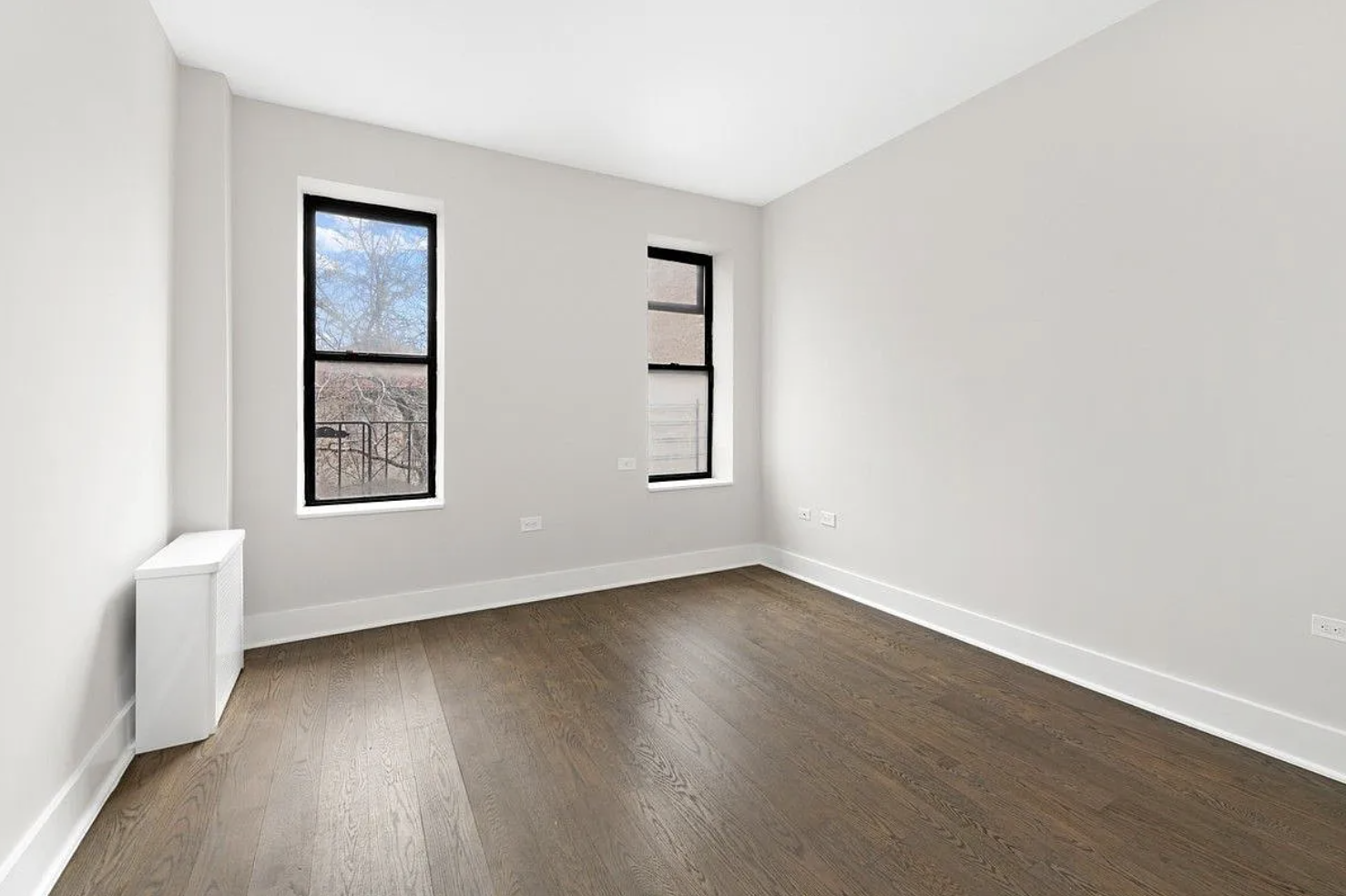 601 Crown Street, Unit C3 Brooklyn, NY 11213 - Photo 5 of 9 an empty room with wooden floor and windows