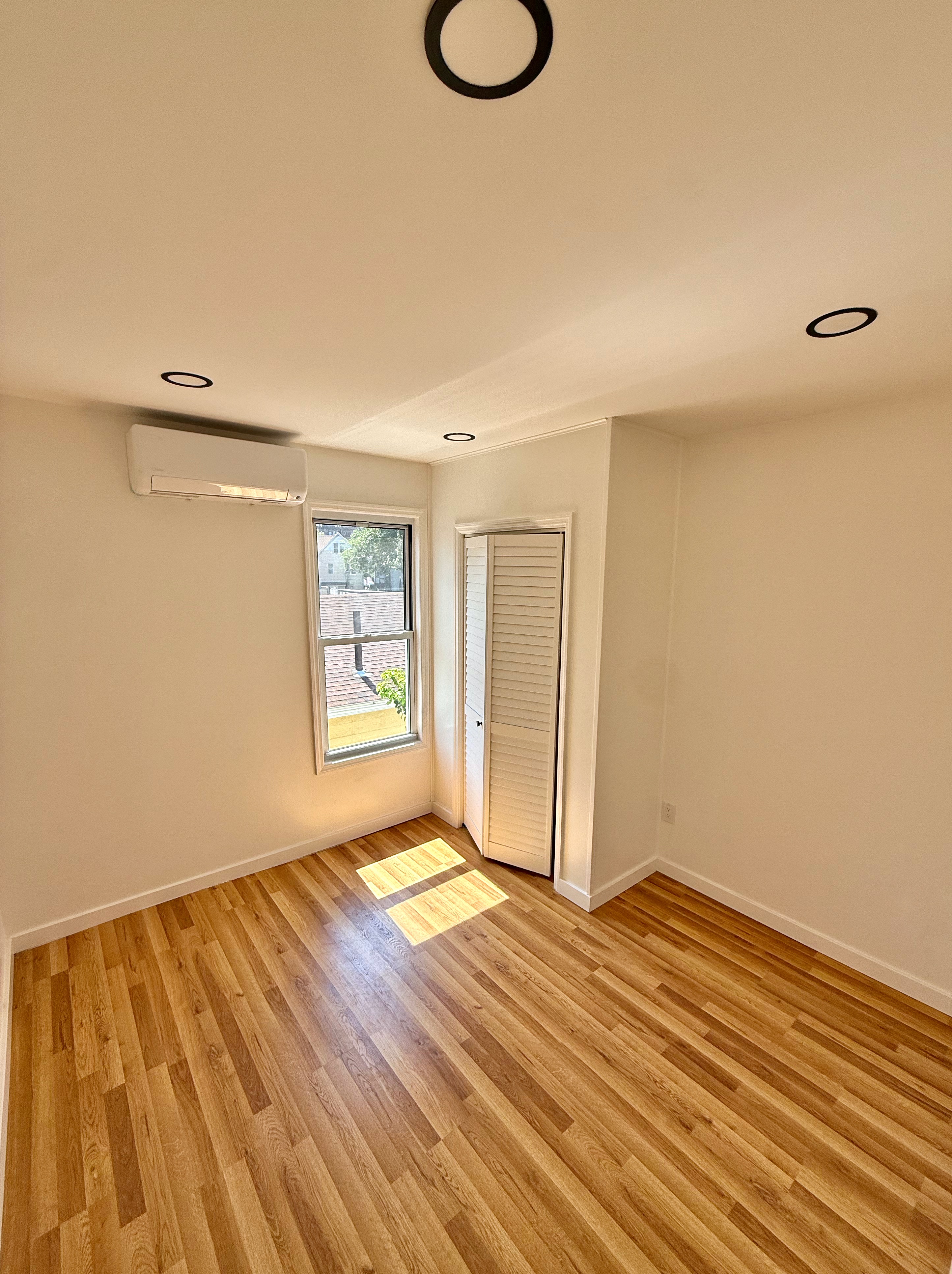 14 Vermont Court, Unit F Brooklyn, NY 11207 - Photo 7 of 10 a view of a room with wooden floor and white walls