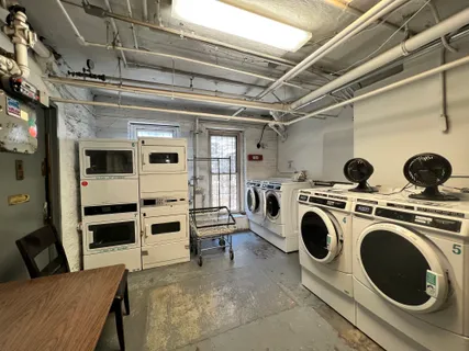 a view of washer and dryer with bathtub in a room