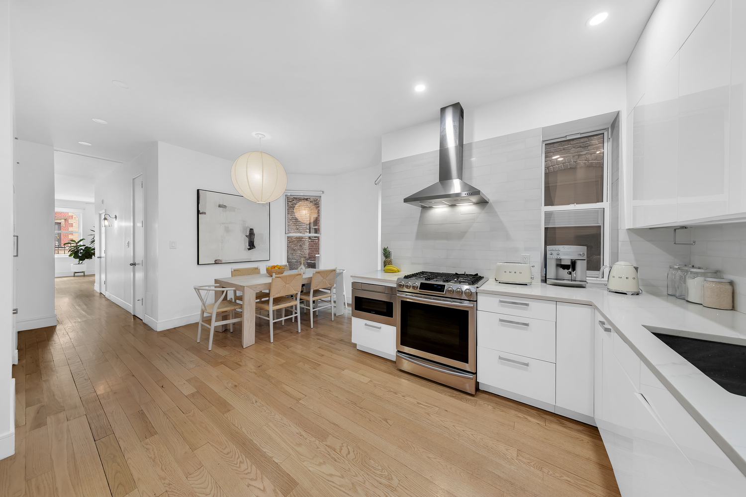 323 West 11th Street, Unit 2WE Manhattan, NY 10014 - Photo 4 of 11 a kitchen with stainless steel appliances granite countertop a stove and a wooden floors