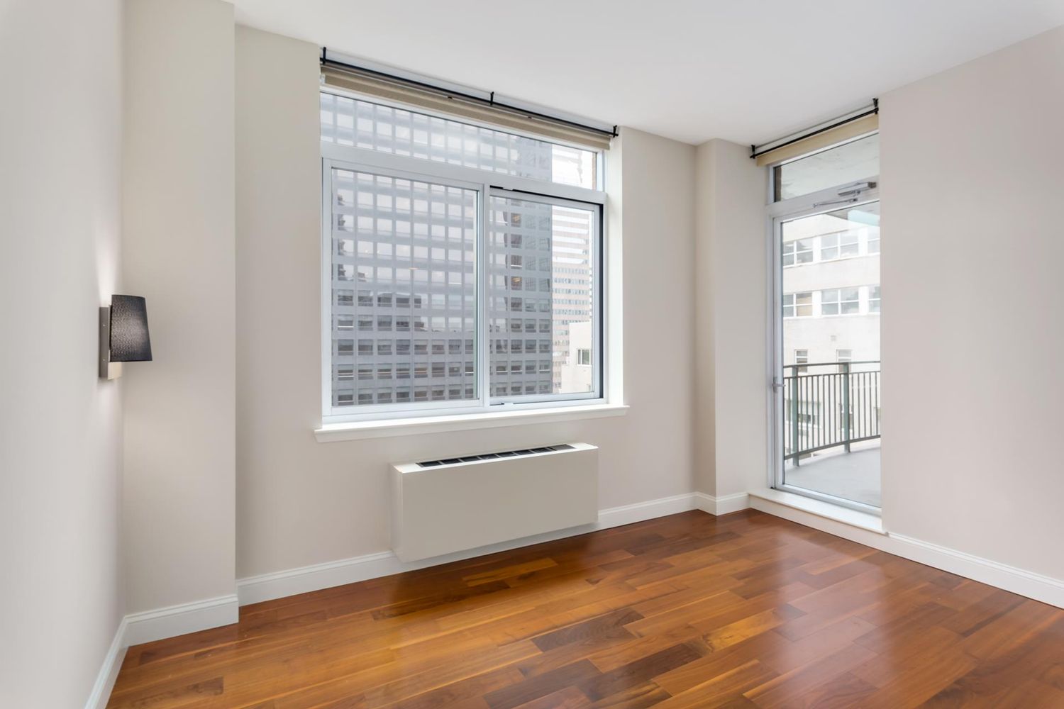212 East 57th Street, Unit 18A Manhattan, NY 10022 - Photo 6 of 14 a view of an empty room with wooden floor and a window