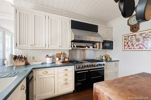 a kitchen with stainless steel appliances a stove a sink and cabinets