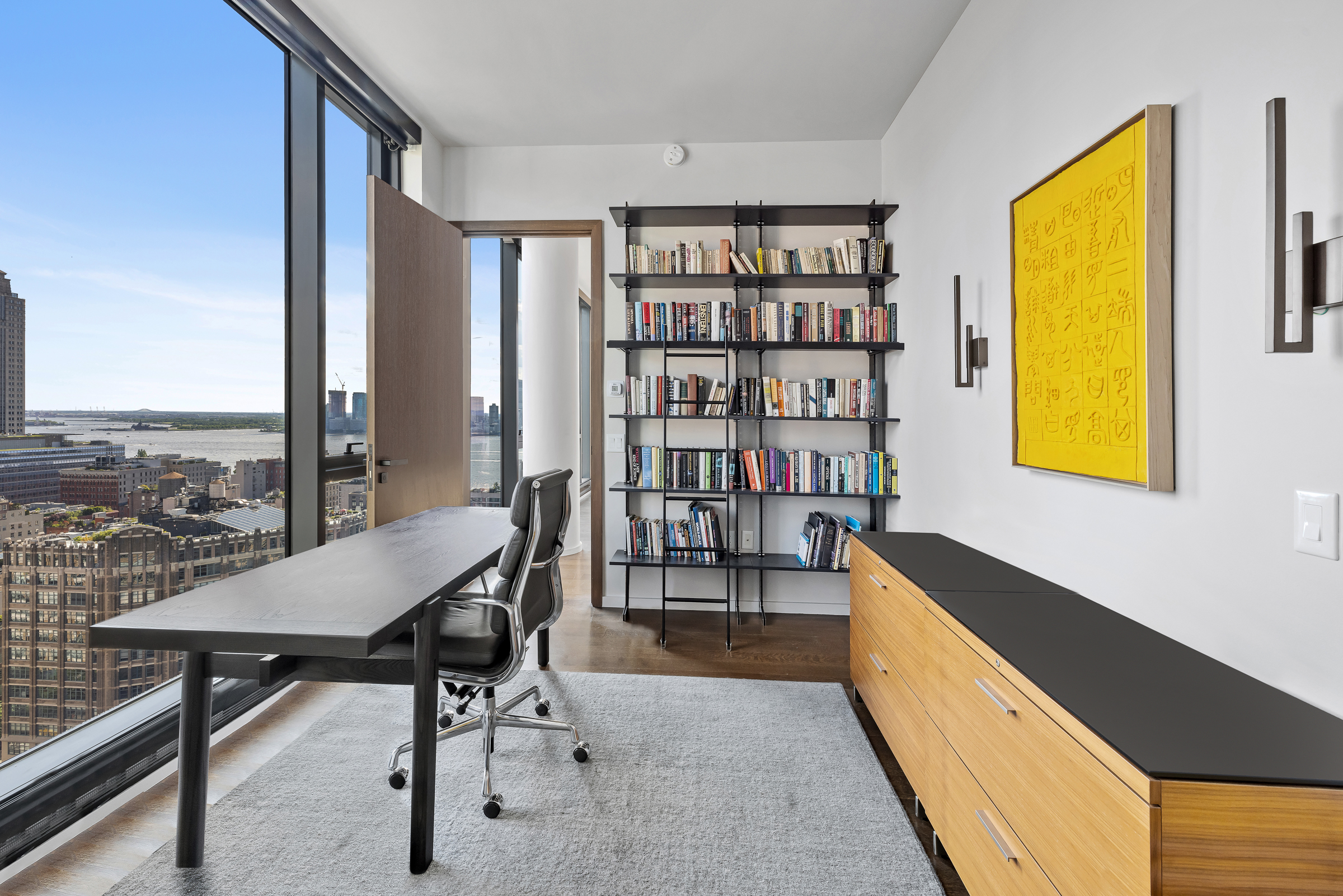 570 Broome Street, Unit 23A Manhattan, NY 10013 - Photo 9 of 13 a view of a workspace with furniture and a bookshelf