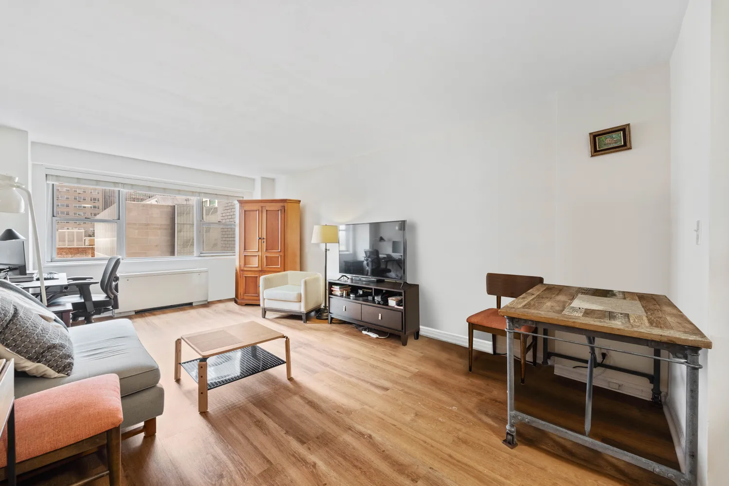 a living room with furniture a flat screen tv and a window