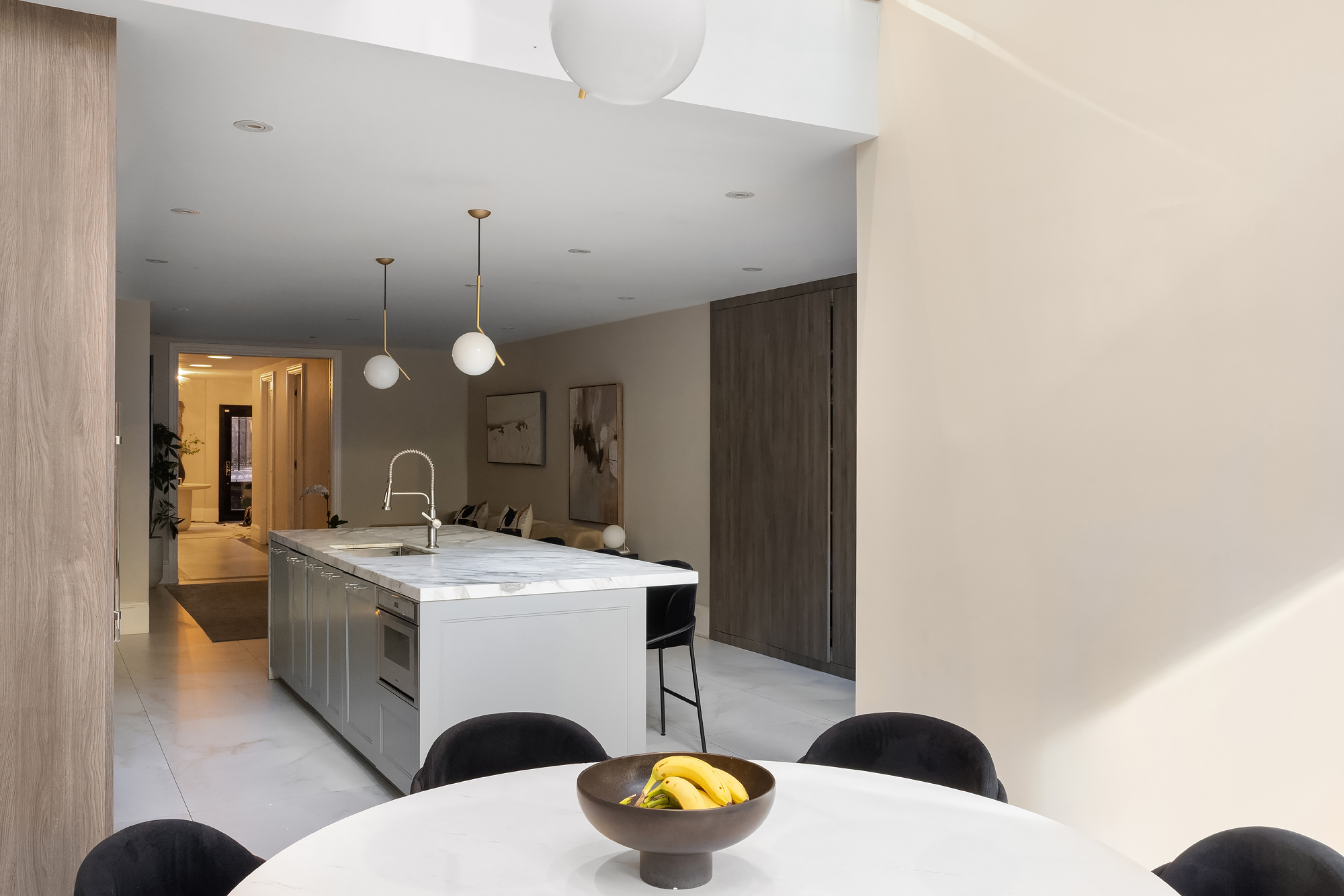 123 East 61st Street Manhattan, NY 10065 - Photo 23 of 31 a large white kitchen with a sink and a stove top oven with wooden floor