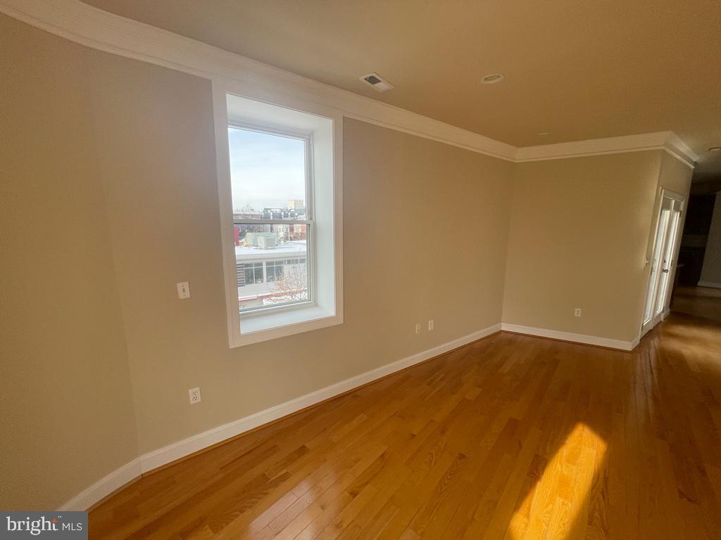 1033 Park Road Northwest, Unit 6 Washington, DC 20010 - Photo 15 of 38 a view of an empty room with wooden floor and a window