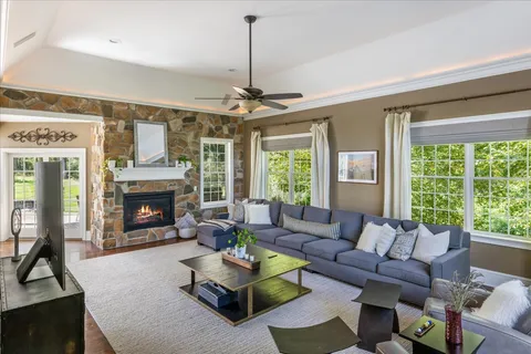 a living room with furniture a fireplace and a ceiling fan