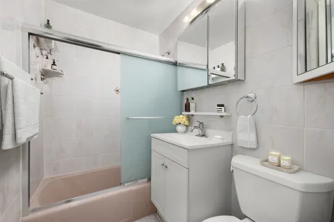 a bathroom with a sink a toilet and shower