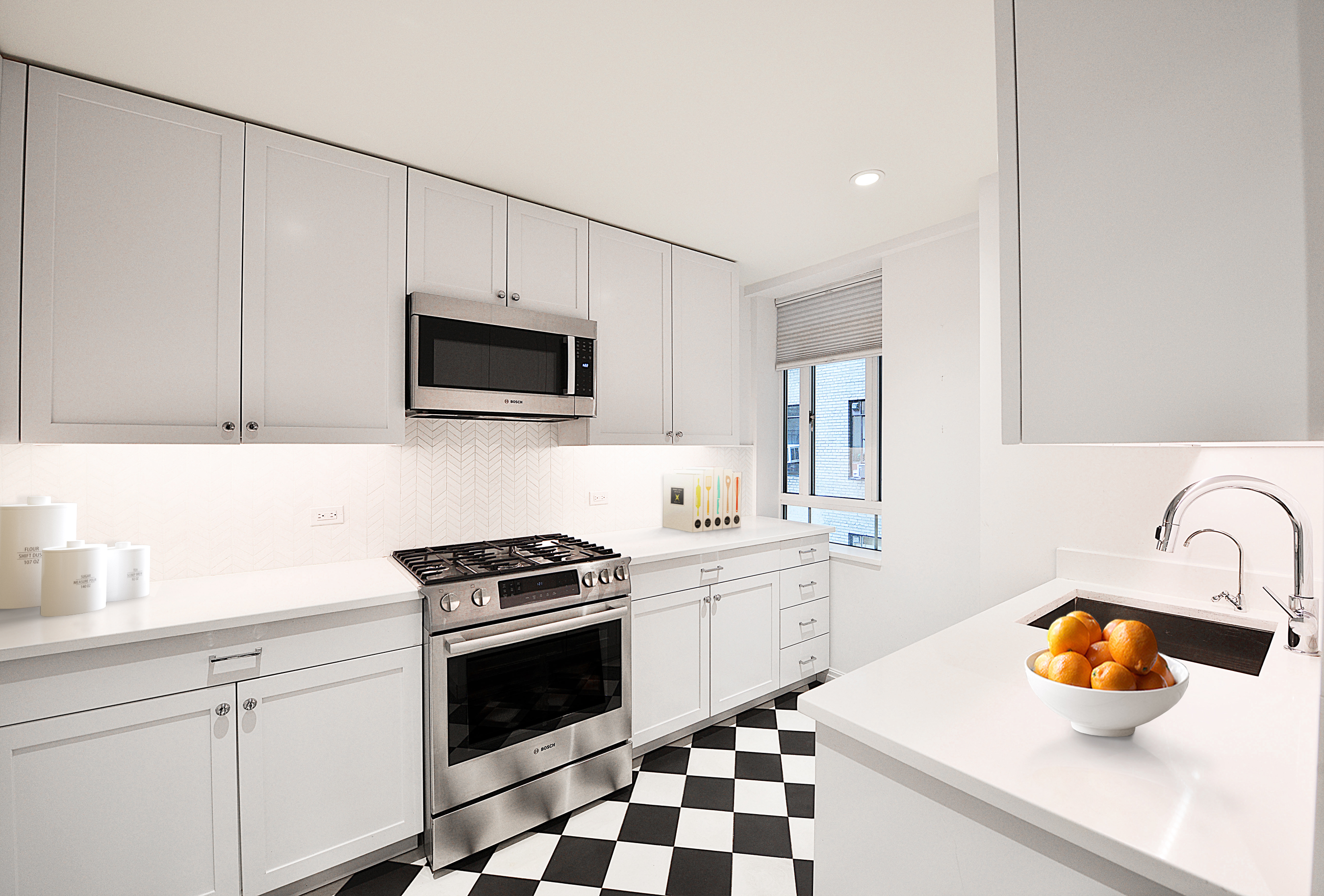 25 Central Park West, Unit 12I Manhattan, NY 10023 - Photo 4 of 7 a kitchen with a sink a stove and cabinets