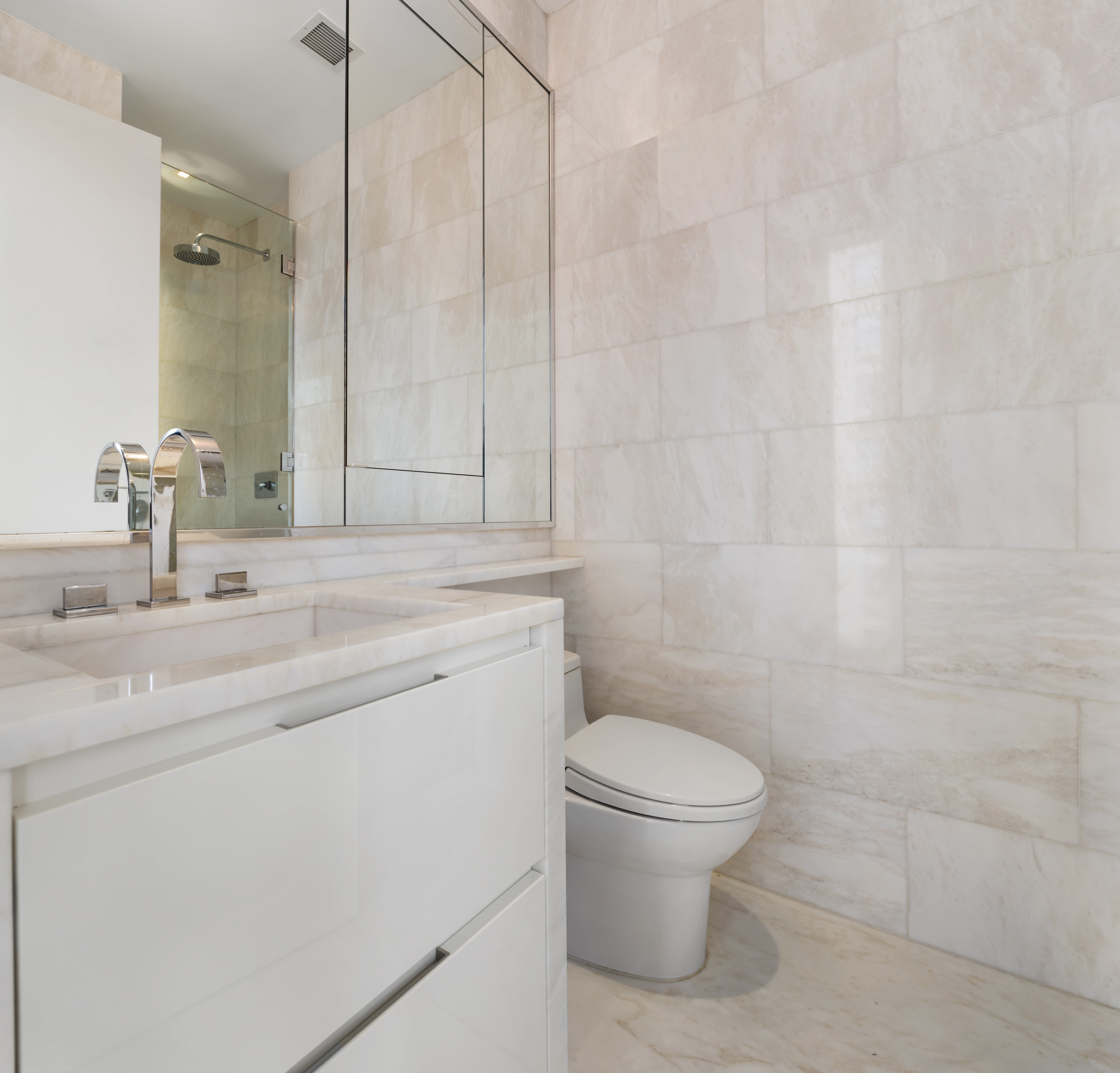 1055 Park Avenue, Unit PH Manhattan, NY 10028 - Photo 15 of 19 a bathroom with a granite countertop sink a toilet and a mirror