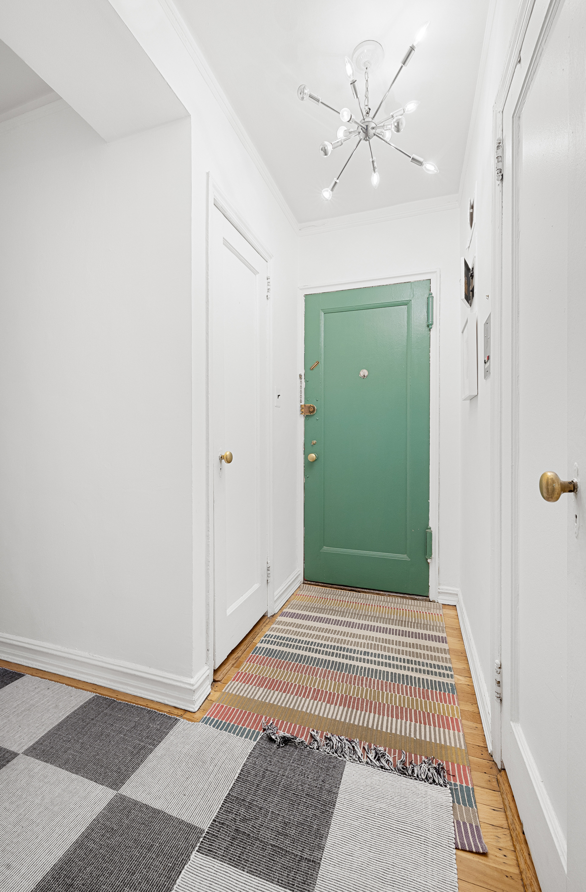 77-11 35th Avenue, Unit 3N Queens, NY 11372 - Photo 14 of 21 a view of a hallway with a chandelier fan and a window