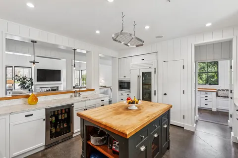 a kitchen that has a lot of cabinets in it and wooden floor