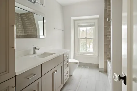 a bathroom with a sink a toilet and a window