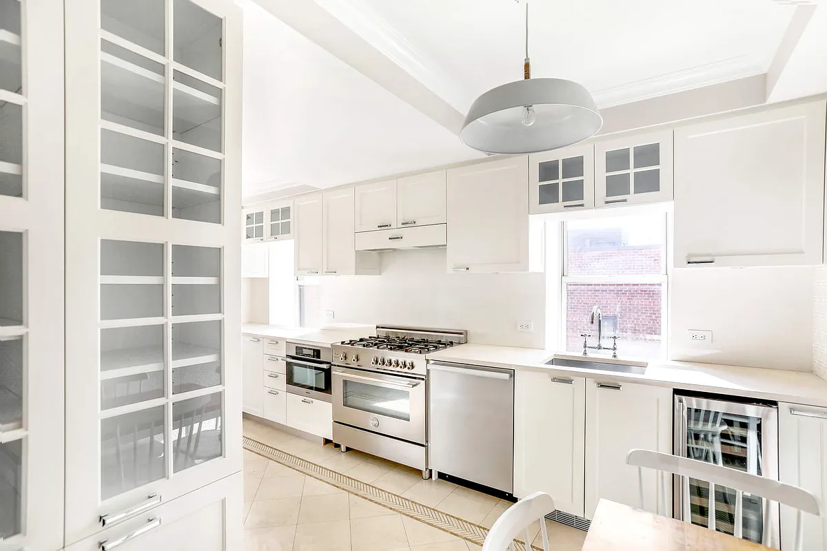 167 East 82nd Street, Unit 9B Manhattan, NY 10028 - Photo 4 of 15 a kitchen with stainless steel appliances cabinets and a window