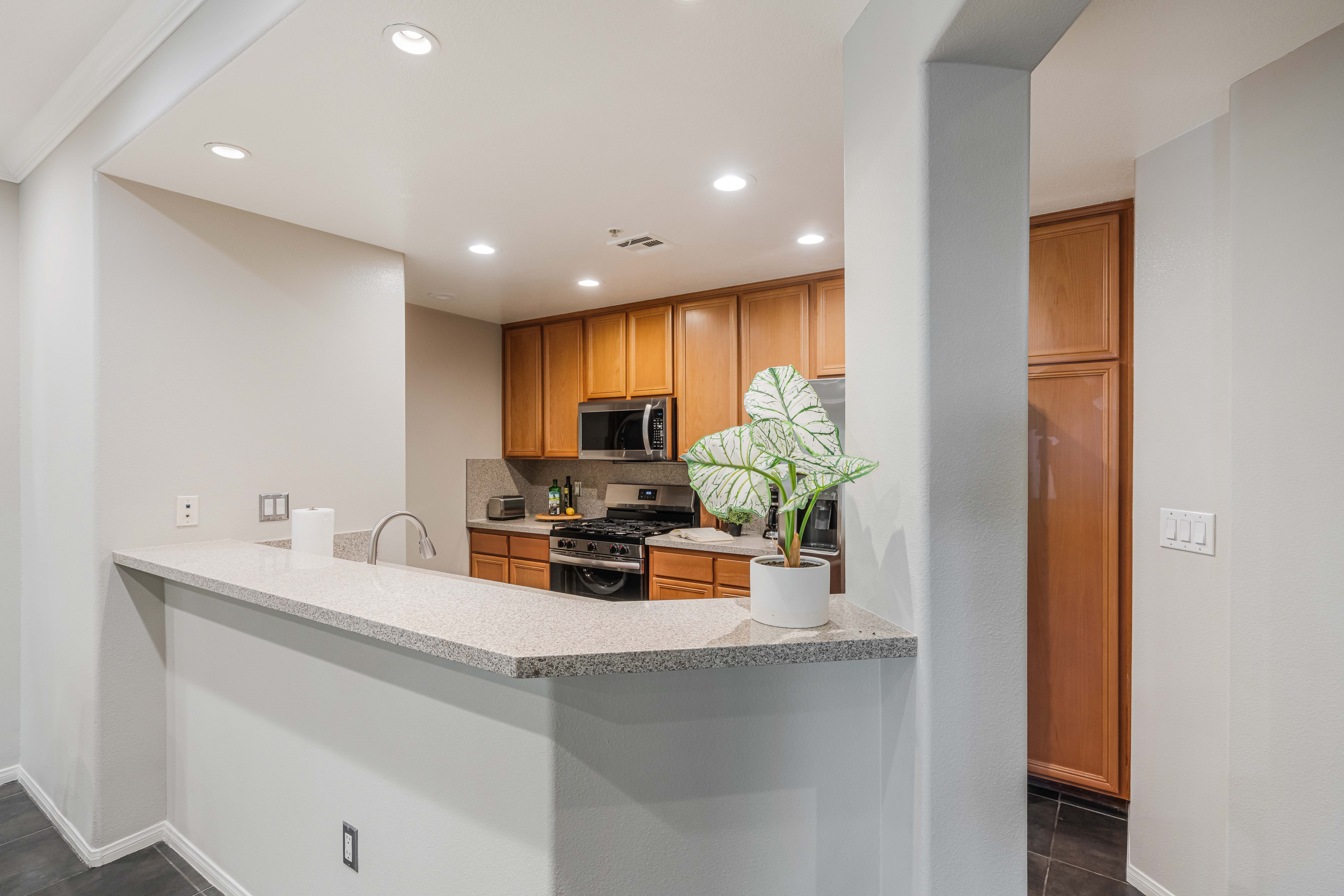 12963 West Runway Road Playa Vista, CA 90094 - Photo 5 of 39 a room with stainless steel appliances kitchen island granite countertop a sink a stove and a refrigerator
