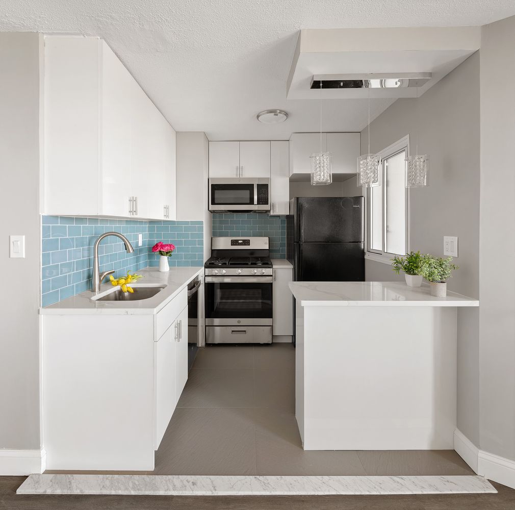 a kitchen with a refrigerator a stove and a sink